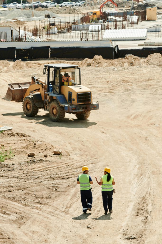 Two People Walking on a Construction Site